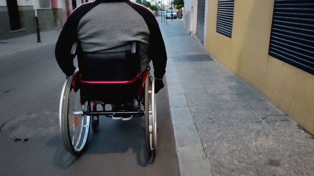 persona en silla de ruedas paseando en la calle
